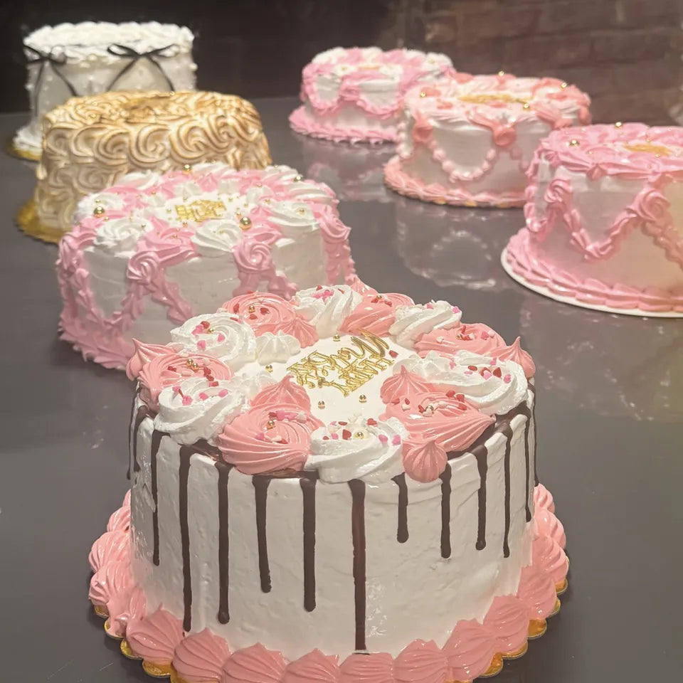 Cakes de merengue rosados y blancos en una mesa de fiesta en Miami